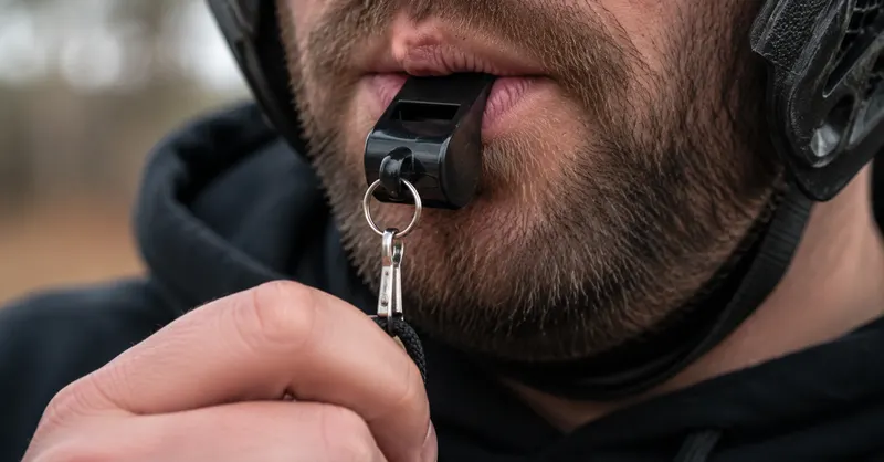 Gros plan sur un animateur donnant un coup de sifflet pour lancer une partie
